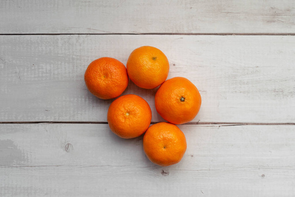 A top view of fresh mandarins on a white wooden surface - Foto, Imagen