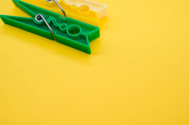 A top view of plastic clothespins isolated on yellow background - Фото, зображення