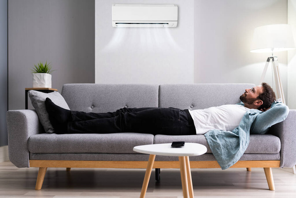 Happy Man Relaxing And Enjoying Cool Air Conditioner Or AC. - Photo, Image