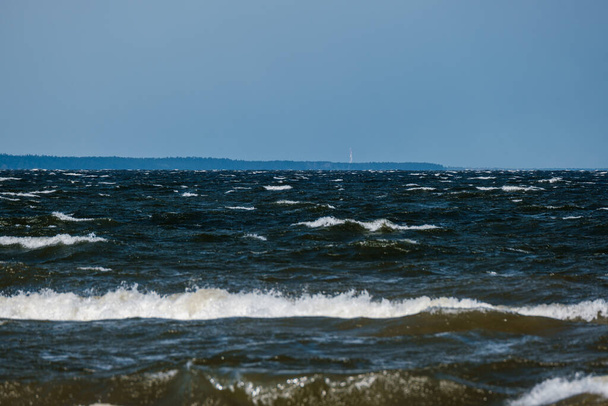 tenger strand fehér homokkal és kék vízzel vihar előtt. hullámok fehér fejjel - Fotó, kép