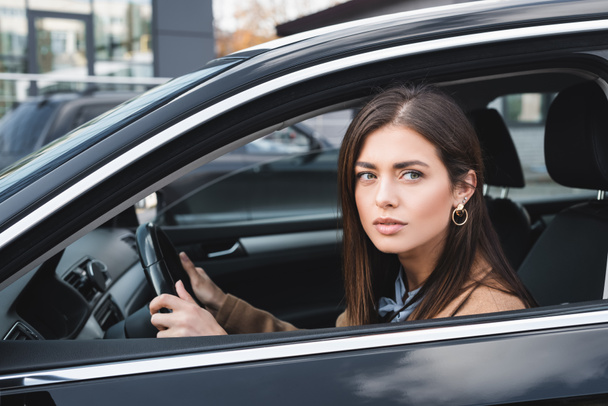 young woman looking out from side window while driving car - 写真・画像