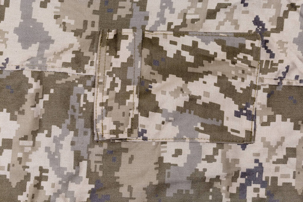 Fragment de pantalon en tissu de camouflage numérique pixellisé de couleur vert olive terne avec poche latérale Patch, fond - Photo, image