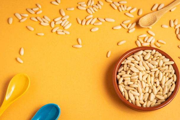Pine nuts on a yellow background and with a space to write - Photo, Image