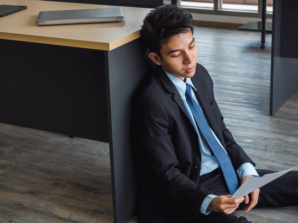 Fiatal ázsiai üzletember rossz híreket kap az elbocsátó levéllel, fáradt, stresszes és szomorú ül a távollétében gondolkodó a helyszínen az irodában. Frusztrált munkavállalói mentális egészségügyi problémák. - Fotó, kép