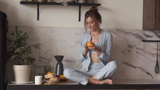 Woman enjoying orange smell in kitchen. - Footage, Video