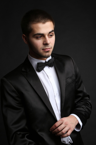Handsome young man in suit on dark background - Fotó, kép