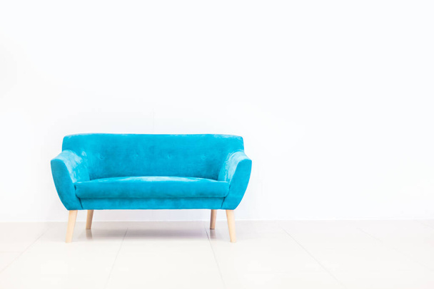 Minimal concept of living interior with bright blue sofa on white floor and background. Scandinavian style wall mockup. - Foto, imagen