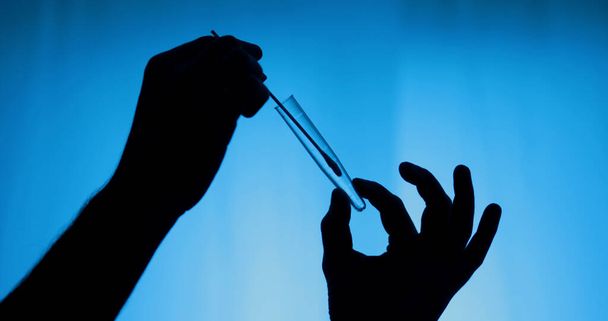 hands putting cotton swab in pcr test tube in backlit - Photo, Image