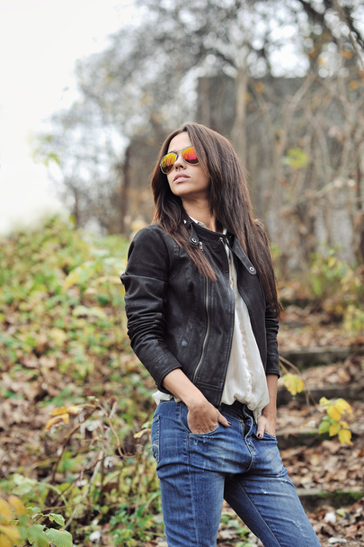 Beautiful young woman in sunglasses posing over nature backgroun - Фото, зображення