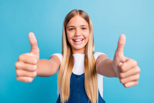Close up photo of pretty optimistic teen blond long hair girl thumbs up wear white t-shirt isolated over pastel blue color background - Foto, Bild