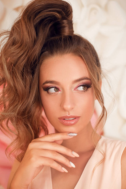 Woman face Make-up portrait. Manicure nails. Beauty fashion model girl pink eyeshadows makeup, tone skin, glossy lipstick and curly hair style. - Fotó, kép