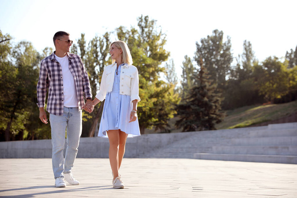 Happy couple walking along city street on summer day - Fotografie, Obrázek