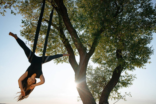 woman doing Anti-gravity Yoga  exercises in the park - Fotografie, Obrázek