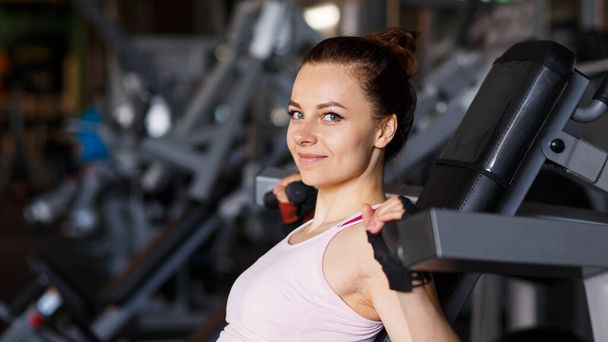 Portrait of young sporty woman in the gym - Фото, изображение