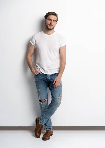Full length studio πορτρέτο του casual νέου άνδρα με τζιν και πουκάμισο. Απομονωμένα σε λευκό φόντο. - Φωτογραφία, εικόνα