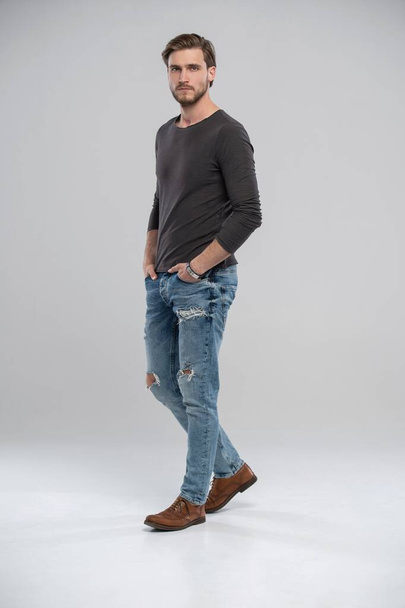 Full length studio portrait of casual young man in jeans and shirt. Isolated on white background. - Valokuva, kuva