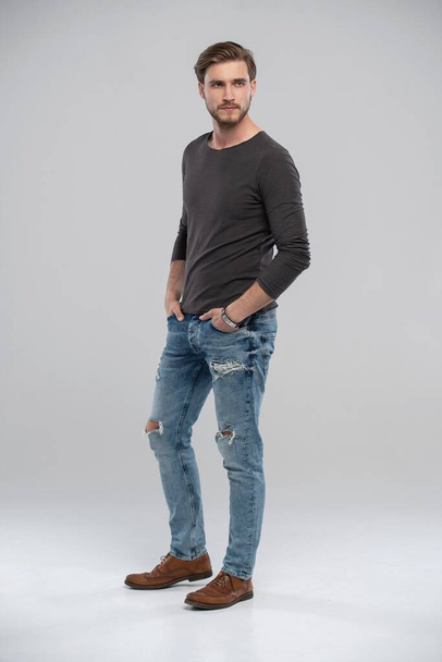Full length studio portrait of casual young man in jeans and shirt. Isolated on white background. - 写真・画像