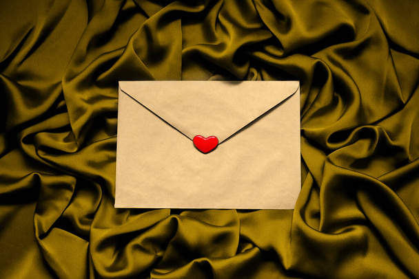 paperi kirjekuori punainen sydän kankaalla kulta tausta - Valokuva, kuva