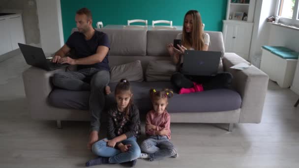 Europa, Italien, Mailand - Familienleben zu Hause während Covid-19 Coronavirus Lockdown Epidemie - Kinder spielen im Wohnzimmer und Eltern arbeiten intelligent - Lombardei rote Zone - Filmmaterial, Video