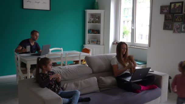 Eurooppa, Italia, Milano - perheen elämäntapa kotona Covid-19 Coronavirus lukitus epidemian aikana - Lapset leikkivät olohuoneessa ja vanhemmat älykäs työskentely - Lombardian punainen vyöhyke - Materiaali, video