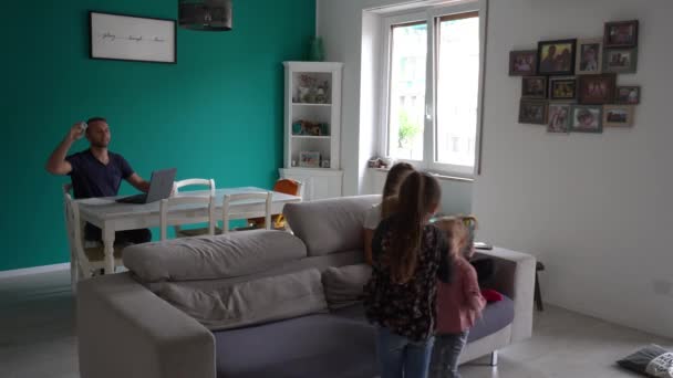 ヨーロッパ、イタリア、ミラノ- Covid-19コロナウイルスのロックダウン流行中に自宅で家族のライフスタイル-リビングルームで遊んでいる子供たちと親のスマートワーキング-ロンバルディアレッドゾーン - 映像、動画