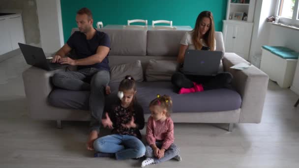 Evropa, Itálie, Milán - rodinný životní styl doma během epidemie zamykání koronaviru Covid-19 - Děti si hrají v obývacím pokoji a rodiče chytře pracují - Lombardie červená zóna - Záběry, video
