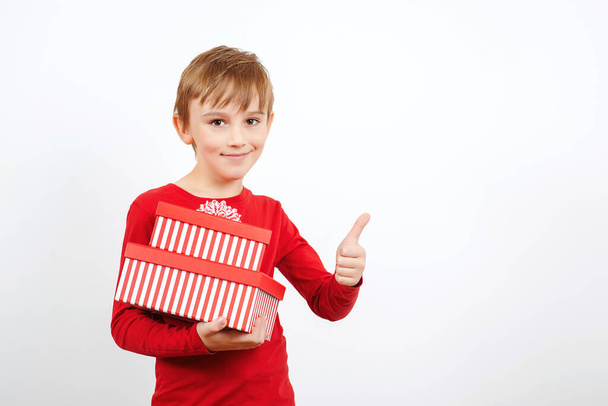 Happy kid holding gift boxes surprise. Happy little boy with presents isolated over white background. Cute boy with present box. Celebration christmas, new year and birthday. Happy childhood. - Фото, зображення