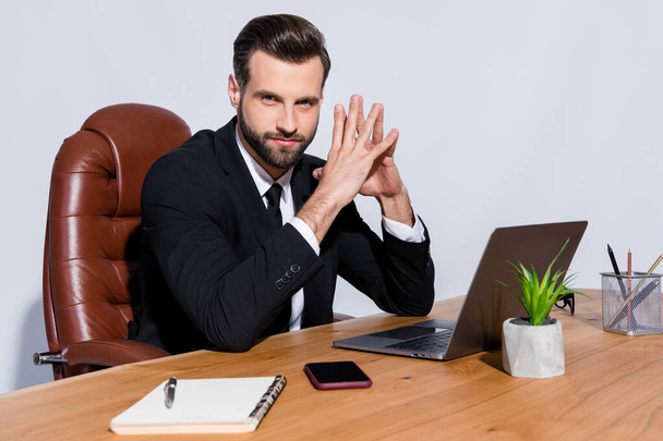 Photo of handsome macho business guy self-confident person notebook table hold fingers together intelligent chief wear black blazer shirt suit sit chair isolated grey background - 写真・画像
