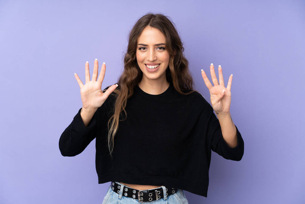 Mladá žena přes izolované fialové pozadí počítání devět s prsty - Fotografie, Obrázek