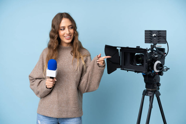 Репортер молода жінка тримає мікрофон і повідомляє новини, вказуючи пальцем на бік
 - Фото, зображення