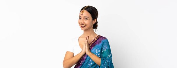 Mujer india joven aislada sobre fondo blanco mantiene la palma unida. Persona pide algo - Foto, imagen