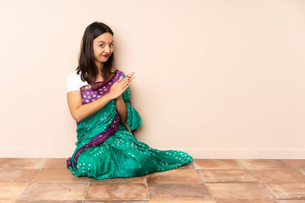 Дівчинка з Індії, яка сидить на підлозі, щось інтригуючи - Фото, зображення