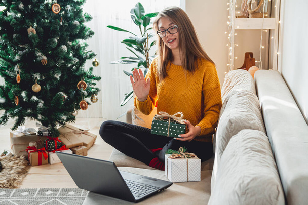 woman with laptop  accepts online congratulations  merry christmas and unpacks gifts - Foto, immagini