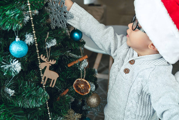 A Little boy decorates a Christmas tree - Foto, immagini