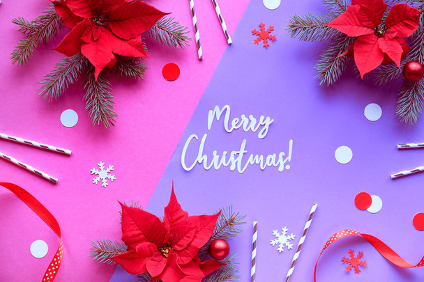 Text Merry Christmas. Top view on red white decorations on purple paper. Trendy geometric background. Poinsettia, paper snowflakes, purple pink dual-color background, paper confetti. - Foto, afbeelding