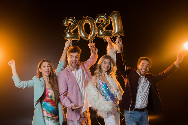 group of excited multicultural friends holding 2021 numbers balloons on black  - Фото, зображення