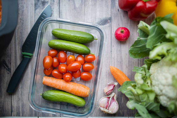 Zanahorias, calabacines, tomates y más verduras en una mesa de madera - Foto, imagen