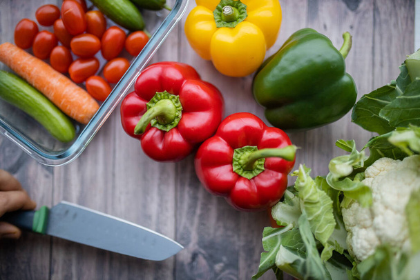 Frische und bunte Paprika und anderes Gemüse auf Holztisch - Foto, Bild