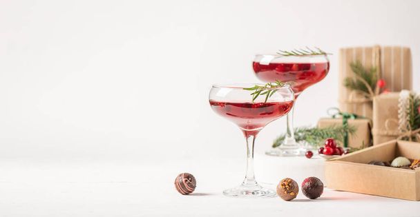 Talvijuoma cocktail karpalo rosmariini lasit valkoinen tausta laatikko suklaata - Valokuva, kuva