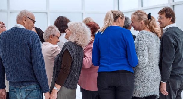 a group of old people standing with their backs indoors - Foto, Bild