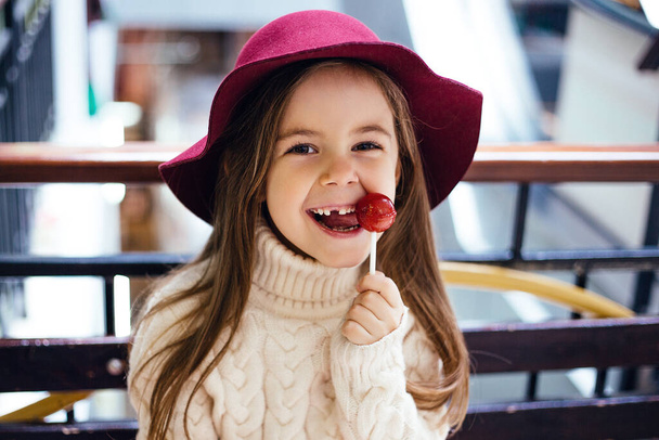 una ragazza con un cappello rosso, senza un dente anteriore, per strada - Foto, immagini