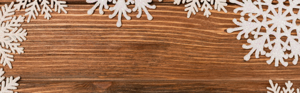 top view of winter snowflakes on wooden background, banner - Photo, image