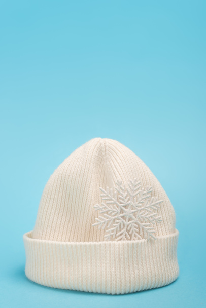 weiße Mütze und Schneeflocke auf blauem Hintergrund - Foto, Bild