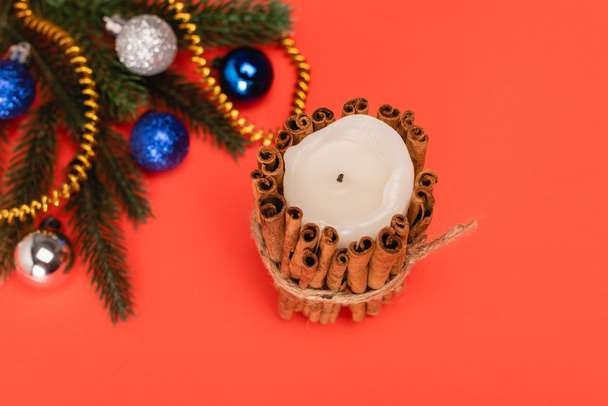 top view of decorated Christmas tree and candle on red background - Foto, immagini