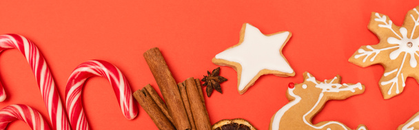 top view of candy canes, spices and gingerbread cookies on red background, banner - Fotografie, Obrázek