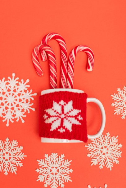 top view of candy canes, snowflakes and mug on red background - Φωτογραφία, εικόνα
