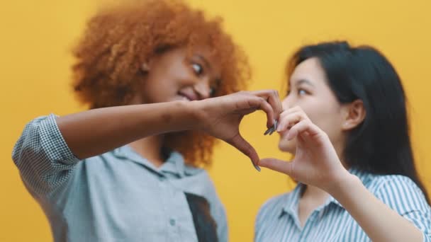 Multiracionális homoszexuális kapcsolat koncepció. Afrikai-amerikai fekete-ázsiai nő, aki kézzel csinál szíveket. Szerelem és szeretet - Felvétel, videó