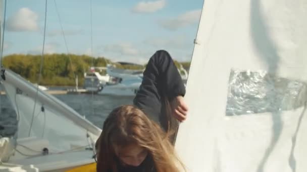 Chcete-li se zúčastnit plachtění regata, hezká dívka připravuje své plachtění jachtu, zkontroluje vybavení. Ve zpomalení - Záběry, video