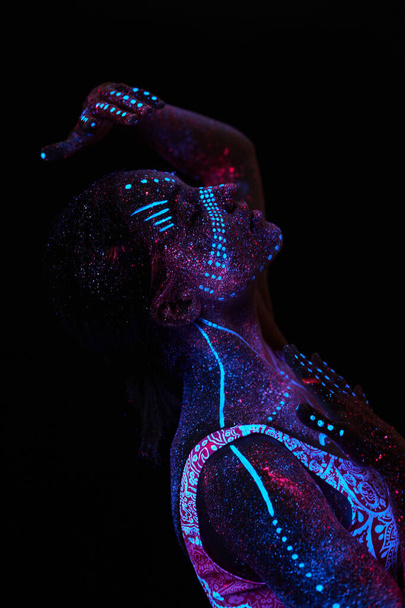 Art woman cosmos in ultraviolet light. Entire body is covered with colored droplets. Girl posing in the dark. Noise, out of focus - Φωτογραφία, εικόνα