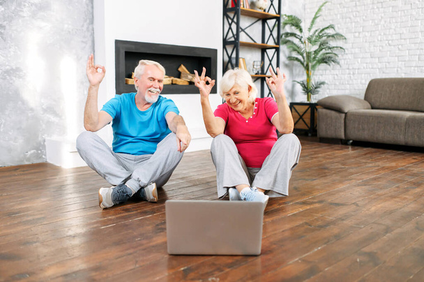 Senior couple practicing yoga with laptop - Photo, Image